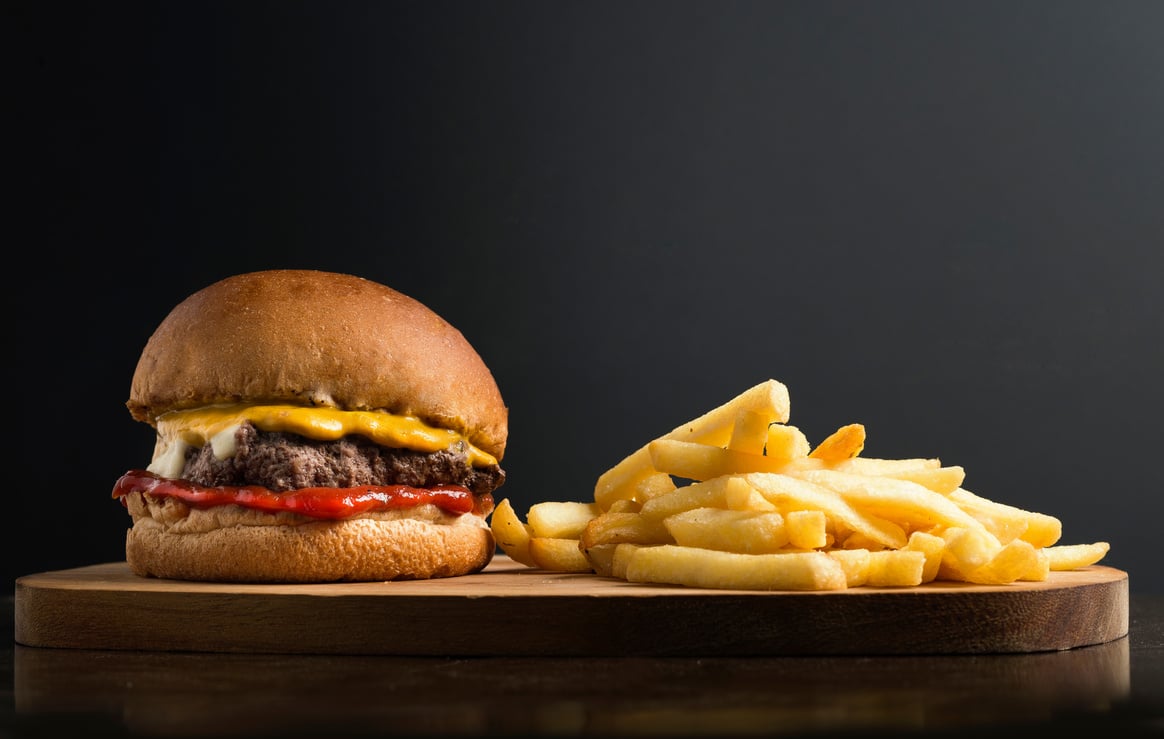 Classic hamburger and french fries on wooden board